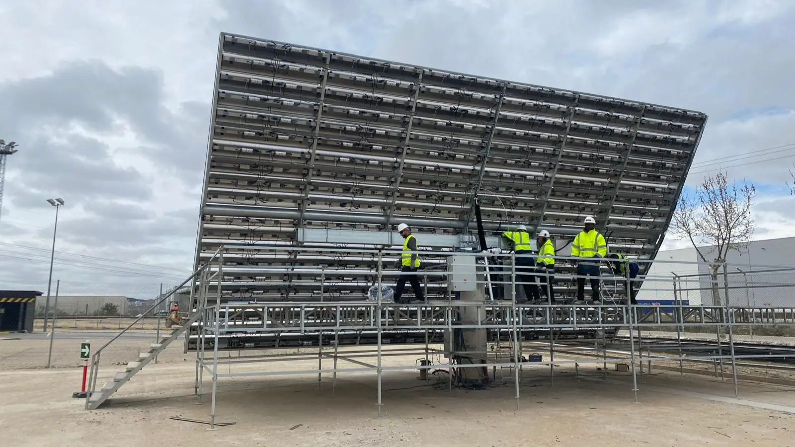 Technicians installing a modular hydrogen system with large panel units at an industrial site.